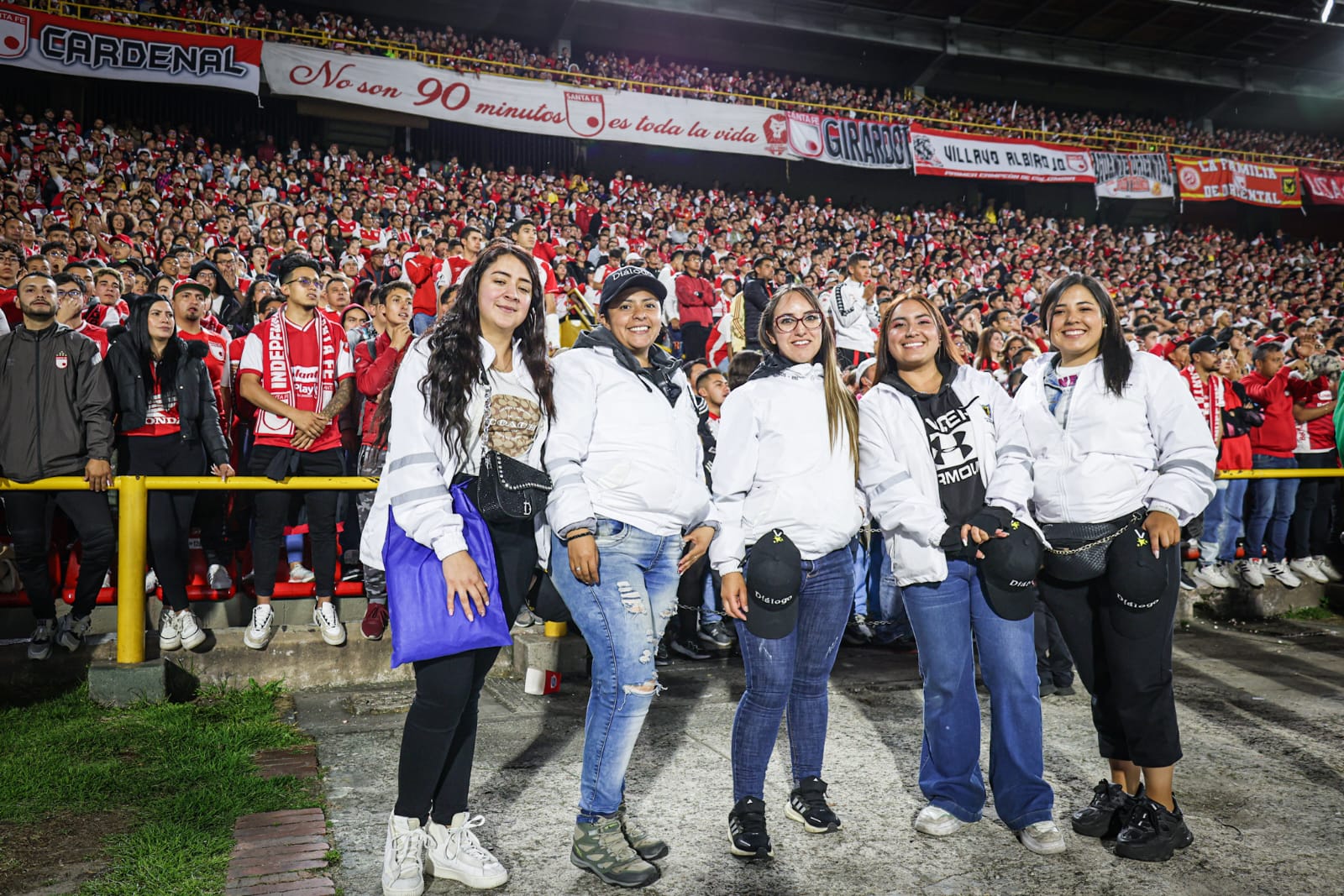 Foto de parte del equipo de Diálogo de la SDG y de fondo la hinchada de Santa Fe