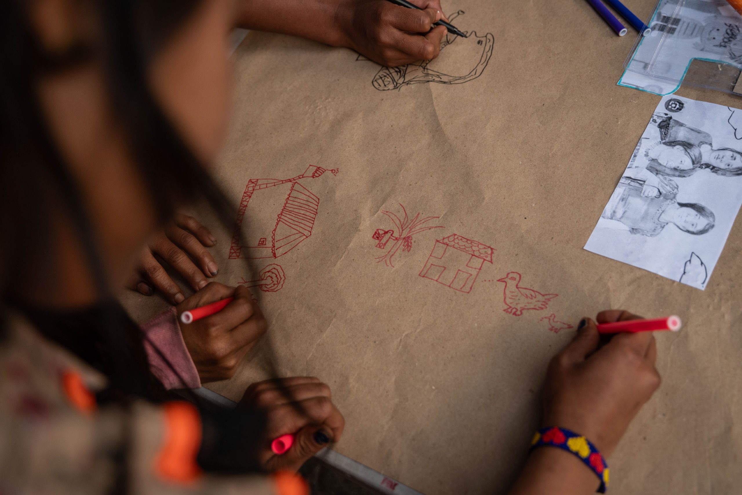 Foto donde se aprecia un papel en el cual miembros de la comunidad Embera están dibujando
