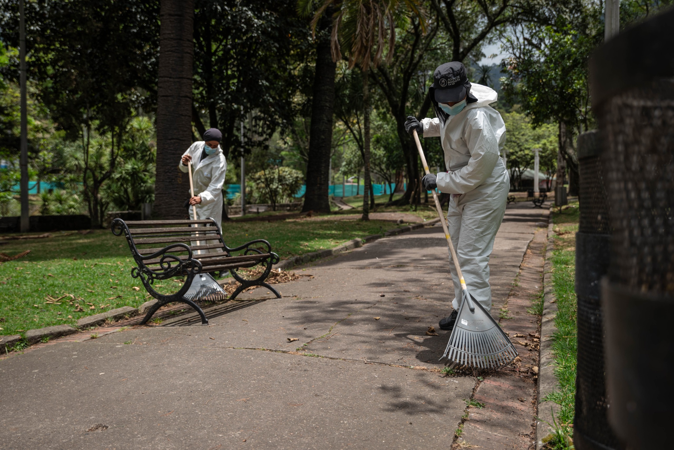 Foto de funcionarios de Aguas de Bogotá barriendo la hojarasca en los corredores del parque