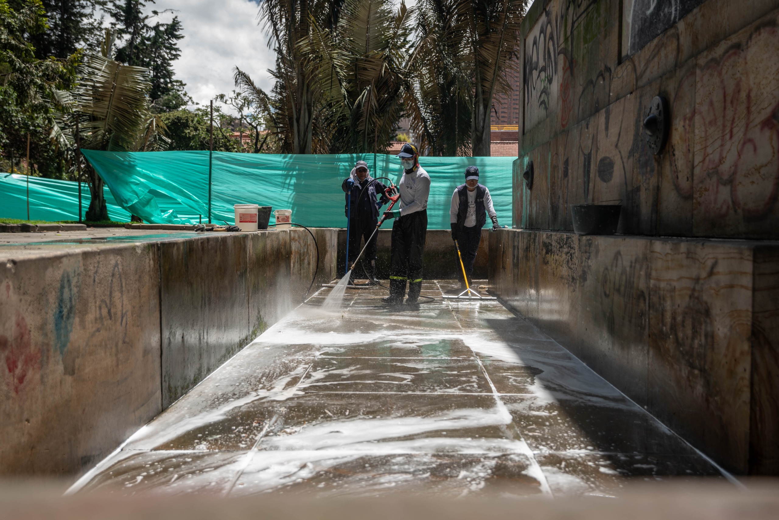 Foto de funcionarios de Aguas de Bogotá lavando la fuente-monumento del parque