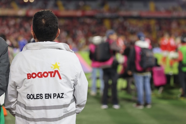 Foto de un funcionario de la SDG con la chaqueta blanca de Diálogo Goles en Paz en el estadio el Campín
