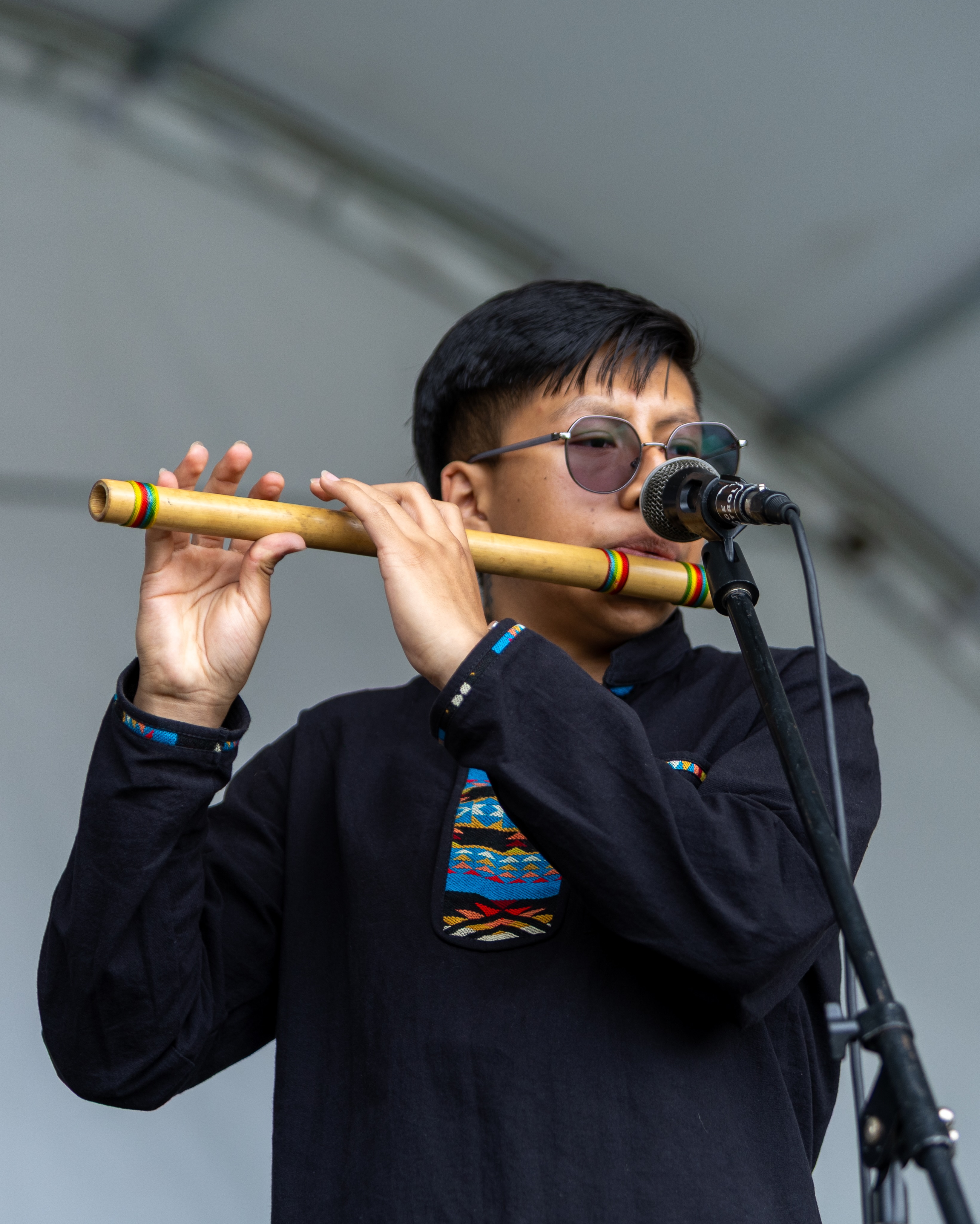 Foto de un joven indígena interpretando una flauta