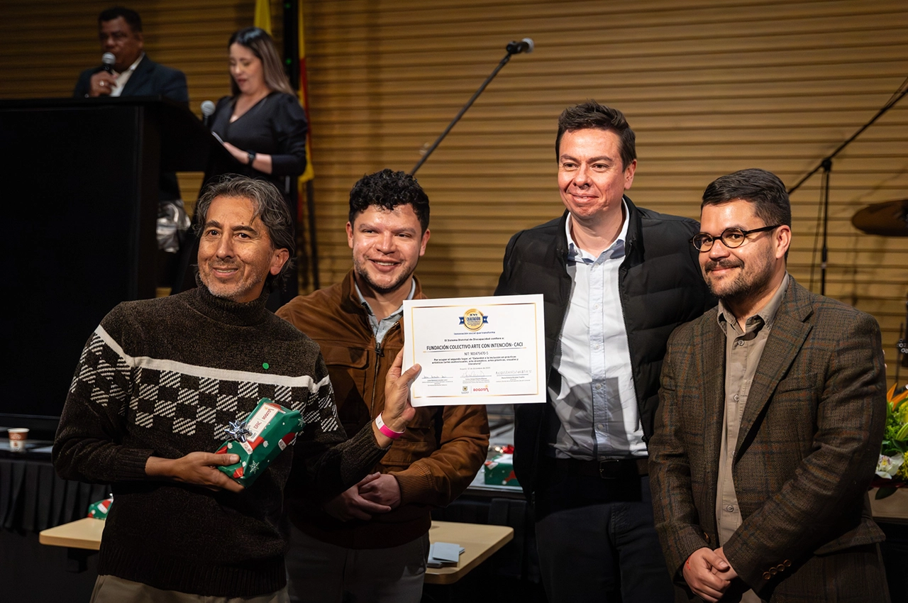 Foto de cuatro hombres sonriendo hacia la cámara.