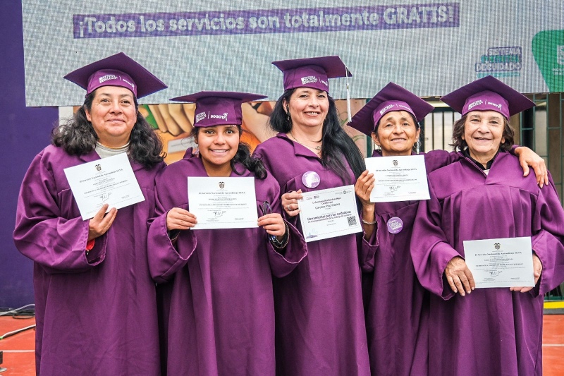 Foto de cinco mujeres cuidadoras sonriendo orgullosas mostrando sus diplomas