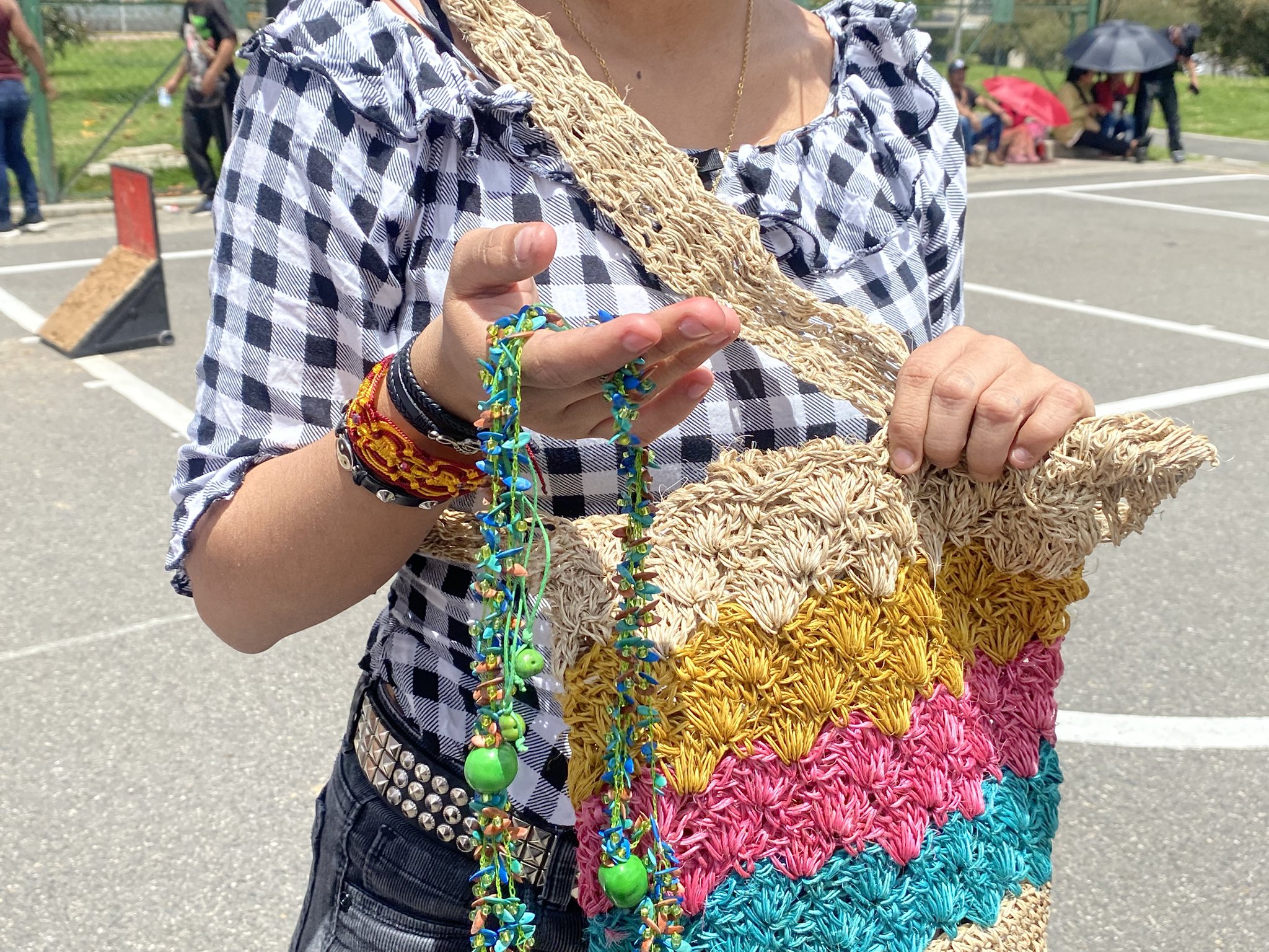 Foto en primer plano de una mujer mostrando una mochila y un collar