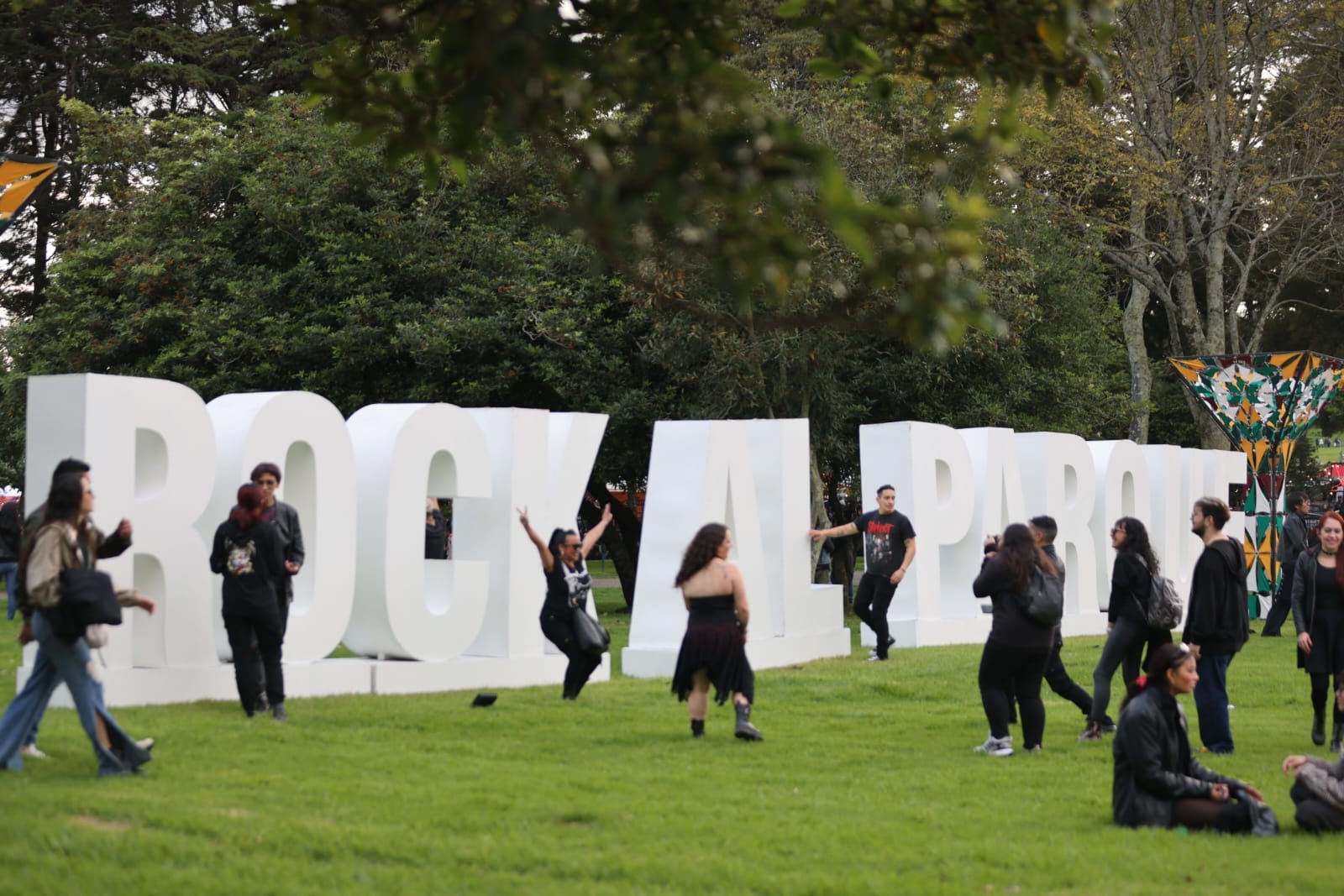 Foto de varias personas en las letras grandes que dicen "Rock al parque"