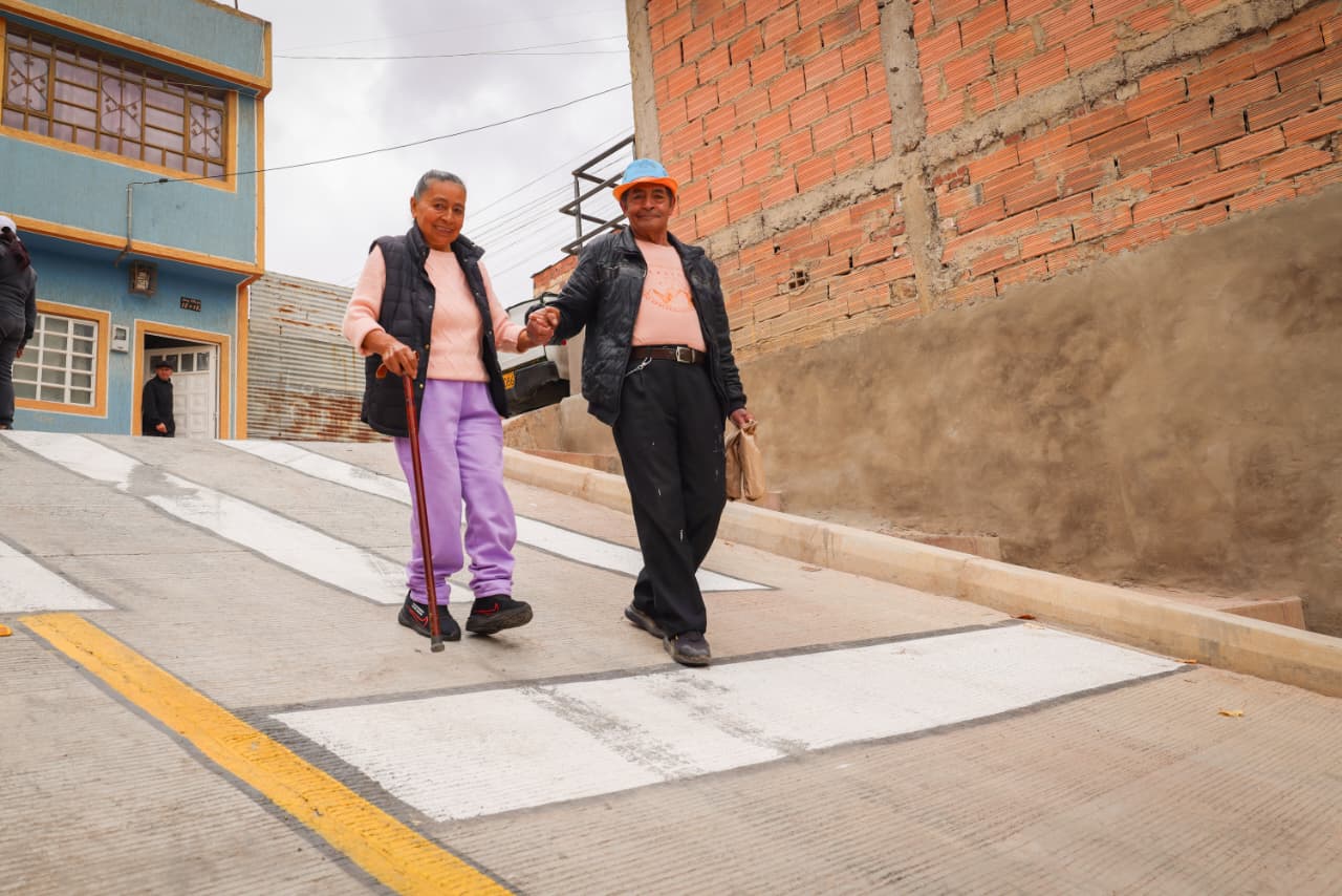 Foto de una pareja de personas mayores caminando sobre una de las nuevas vías pavimentadas