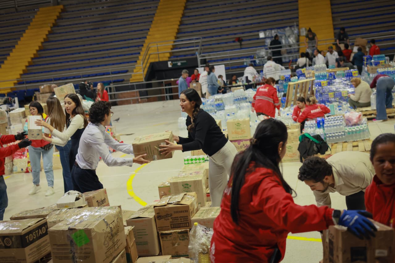 Foto de un grupo de personas organizando las donaciones dentro del Palacio de los Deportes