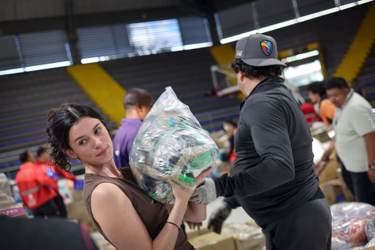 Foto de una cadena humana recibiendo dondeaciones donde se destacan dos mujeres jovenes