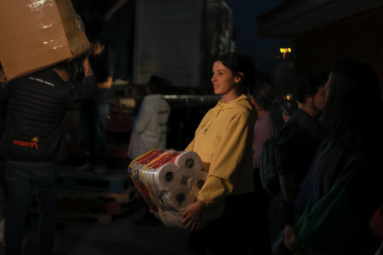 Foto de una mujer joven llevando una donación en horas de la noche
