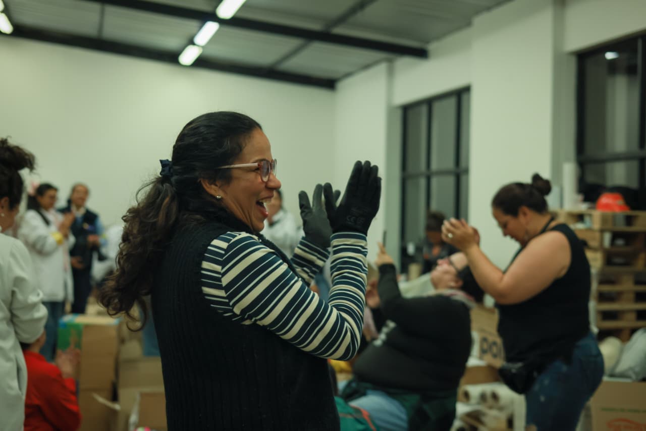 Foto de un grupo de mujeres aplaudiendo felices por la llegada de donaciones