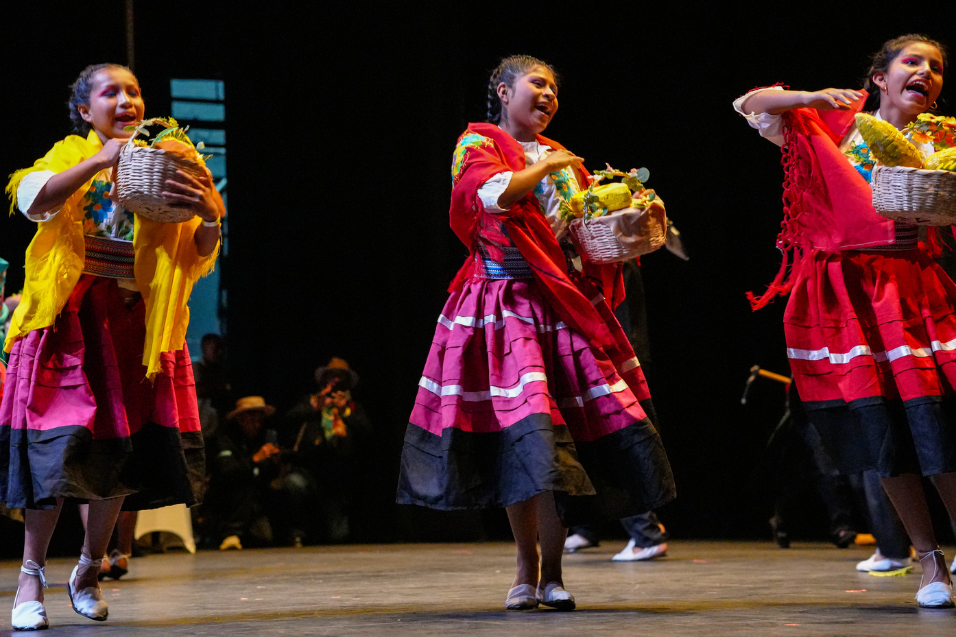 Foto de la presentación de tres mujeres indígenas bailando