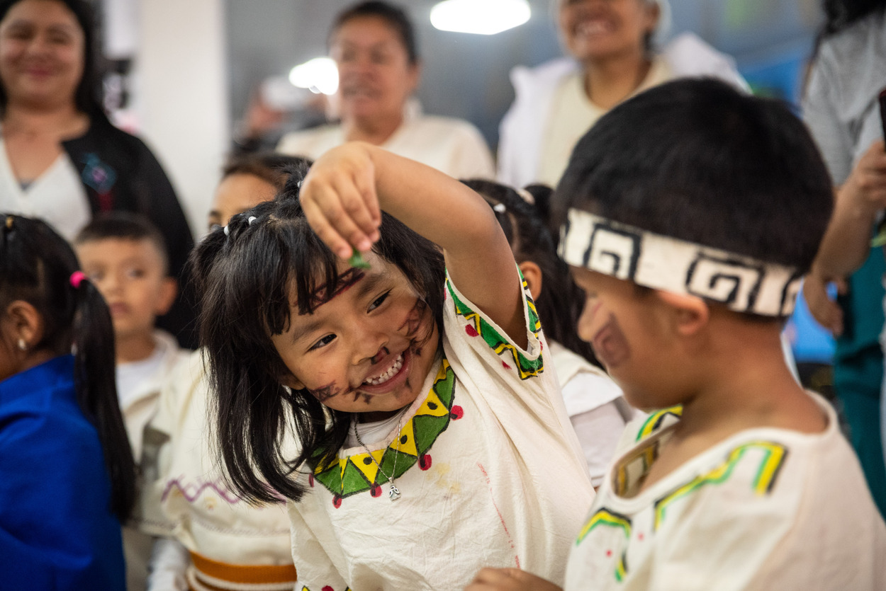 Foto de una niña y un niño indigena jugando felices