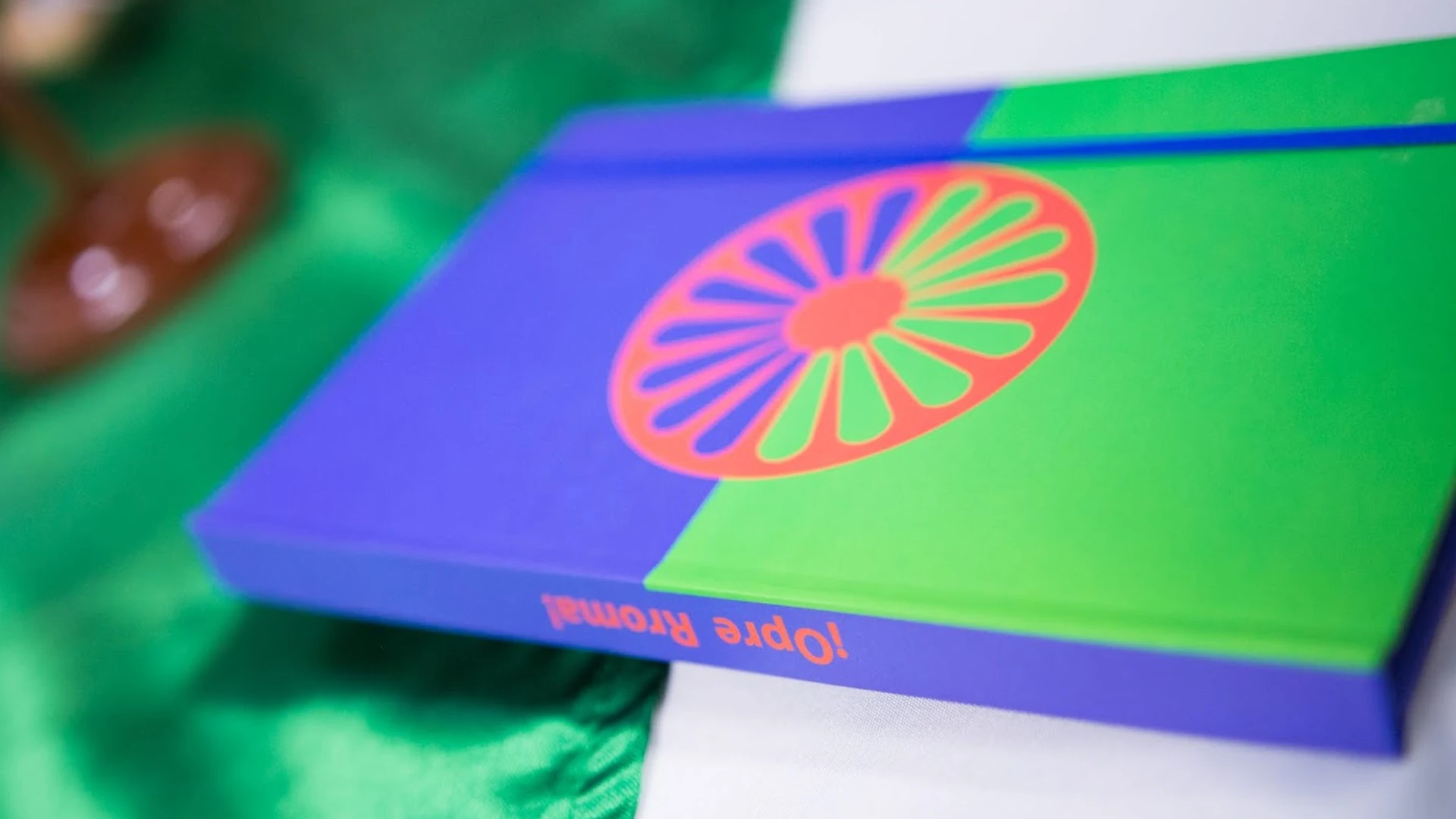Foto de un cuaderno donde la portada tiene la bandera del pueblo Rrom