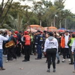 En la fotografía se puede apreciar a tres funcionarias y funcionarios de Diálogo en medio de una manifestación de la ciudadanía.
