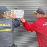 Policía y personal de la Alcaldía cerrando un establecimiento.
