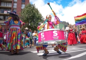 Foto de una persona en la marcha interpretando un istrumento musical