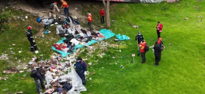 Fotografía de un espacio aledaño a un puente, en el cual están recogiendo escombors y basura.