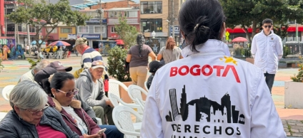 Fotografía de una funcionaria con chaqueta blanca de diálogo en campo