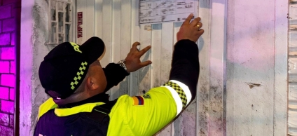 Policía en operativo colocando sellos en el establecimiento