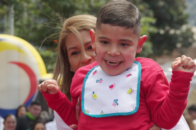 Foto de una señora con un niño especial, ambos están felices
