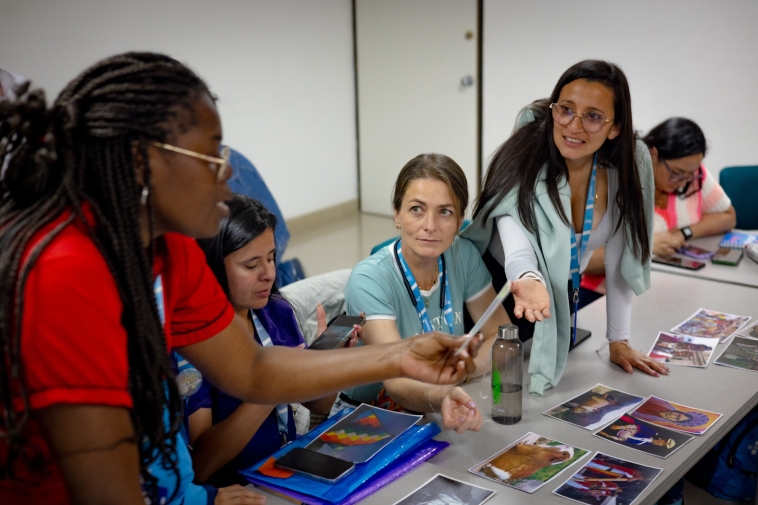 Foto de mujeres viendo fotos en una mesa.