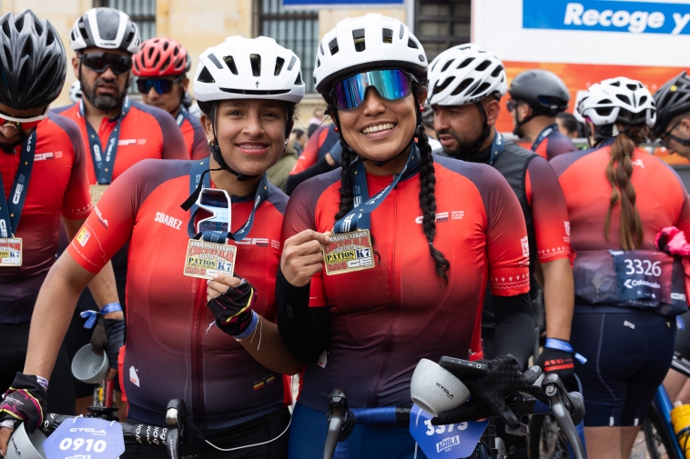 Foto de dos cliclistas mujeres sonreindo y mostrando sus medallas