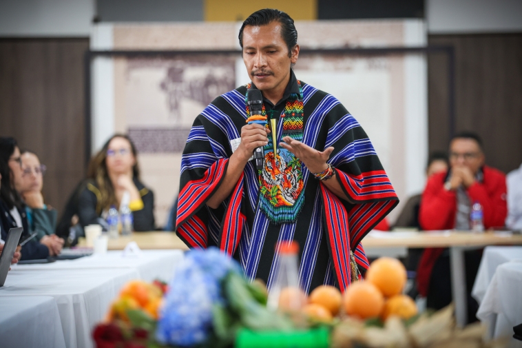 Foto de un hombre de los pueblos indígenas dirigiéndose a la mesa