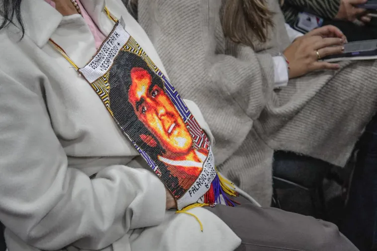 Foto de un saco gris con una ilustración de un rostro.