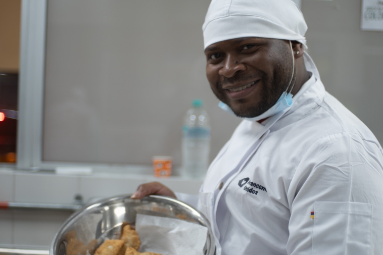 Foto de un cocinero raizal feliz mostrando unos amasijos
