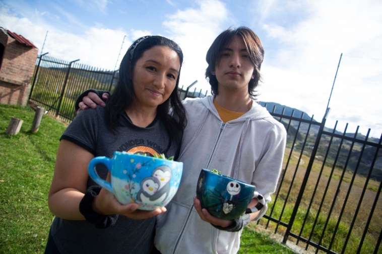 Foto de Diana Buitrago y un joven mostrando dos de sus productos