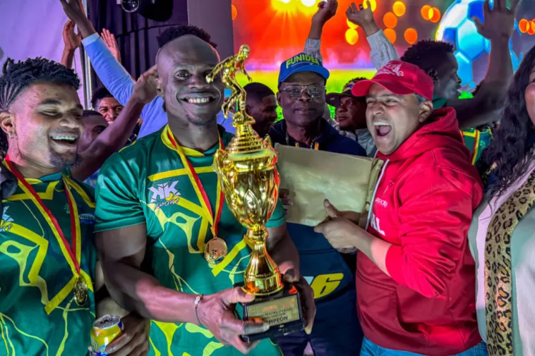 Foto de dos jugadores ganadores del torneo afro recibiendo el trofeo por parte de dos personas.
