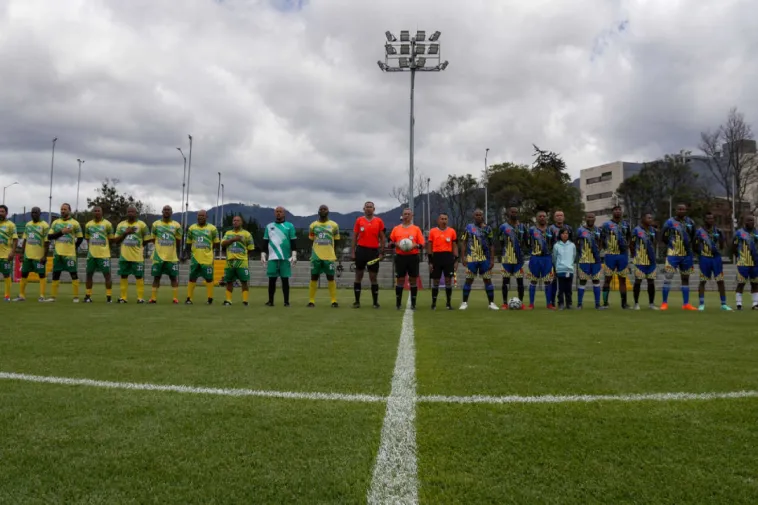 Foto panoramica de dos equipos rivales formados antes de iniciar el partido.