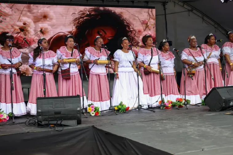 Foto de un grupo de mujeres mayores negras y afrocolombianas en escena con instrumentos y la fuerza de sus voces