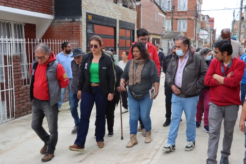 foto en la que se encuentra la alcaldesa junto a la comunidad caminando por una de las calles del barrio. 
