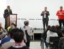 La imagen muestra un encuentro institucional con participación de la comunidad. En el escenario, varios representantes intervienen ante los asistentes durante una jornada de diálogo, mientras el público sigue la presentación desde el auditorio.