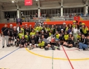 Participantes de un torneo de roller derby posan en grupo dentro de un escenario deportivo, con uniformes, cascos y patines, en un ambiente de celebración, integración y compañerismo.