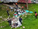 Fotografía de un espacio aledaño a un puente, en el cual están recogiendo escombors y basura.